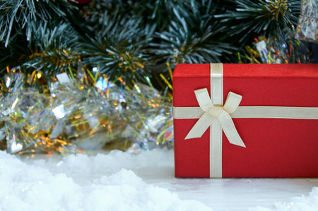 Christmas composition with Christmas tree branches, red tinsel, gift boxes and silver tinsel