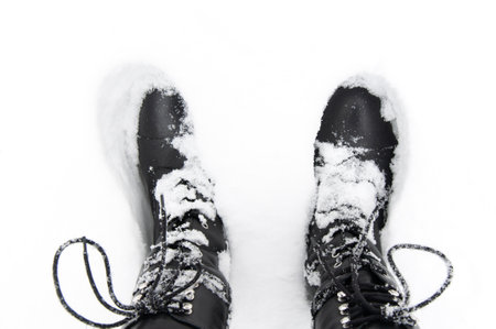 Black winter boots on the snow, top viewの写真素材