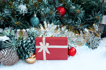 Christmas composition with Christmas tree branches, red tinsel, gift boxes and silver tinselの写真素材