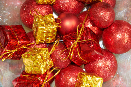 Christmas composition with red balls on yellow gifts in silver tinselの写真素材