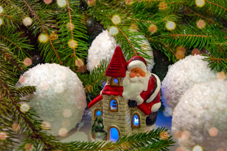 Santa Claus on a house near the branches of a Christmas tree. Background for New Year and Christmas.の写真素材