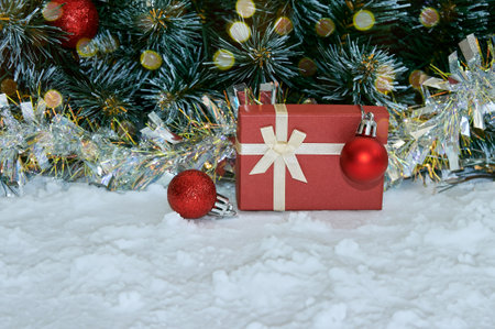 Christmas arrangement with Christmas tree branches, red tinsel, red gift and silver tinsel. Christmas holiday picture with copyspaceの写真素材