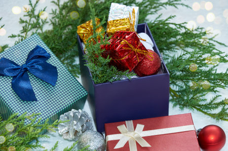 Christmas composition with Christmas tree branches, red tinsel, gift boxes and silver tinselの写真素材