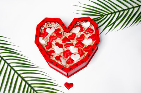 Red heart shaped gift box with white and red hearts on white background.の写真素材