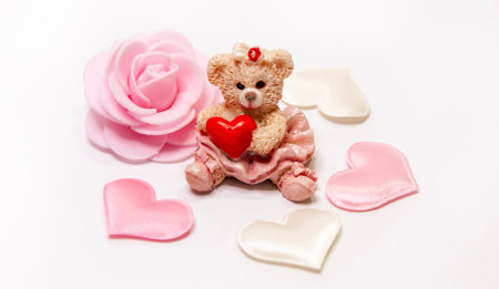 Teddy bear with red heart and pink rose on white background.の写真素材