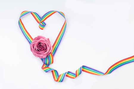 Heart from a ribbon with multi-colored lines and a rose. Color palette symbols of the LGBT.Sample congratulations of sexual minorities. Greeting card. Rainbow Colorsの写真素材