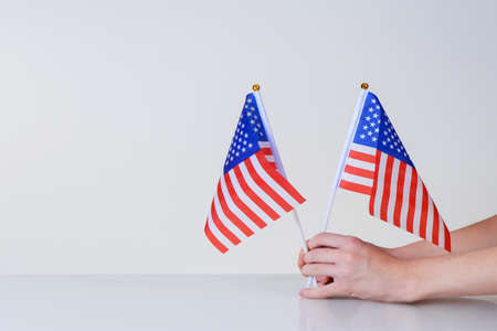 amamerican flags in hands on a light background over the tableerican flags in hands on a light background over the tableの写真素材