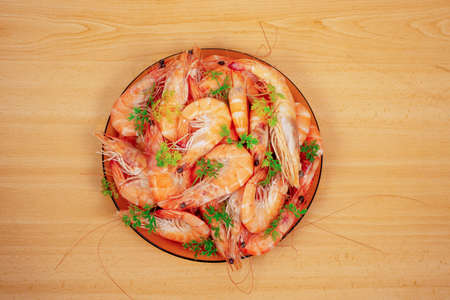 hrimp beautifully decorated with parsley in a plate on the wooden table, top viewの写真素材