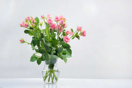 bouquet and bouquet pink roses in water in a glass vase isolated on a white backgroundの写真素材