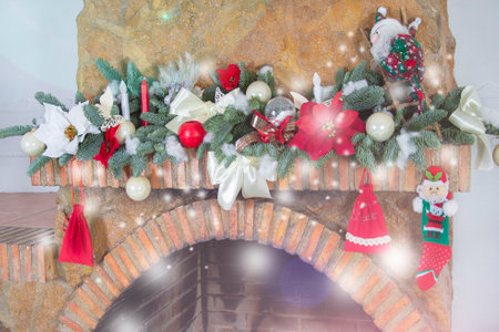Christmas background,Christmas background, decorated Christmas tree garland on a stone fireplace with bright lights and decorative glass scars and candles, Santa Claus toy. Christmas interior decorの写真素材