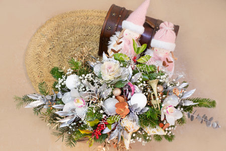 decorating the house for Christmas from festive dolls, a chest and a floristic composition of a Christmas tree, balls, sparkles, toys, red berries and orchid flowersの写真素材