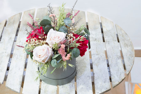 beautiful delicate bouquet of stabilized flowers, roses,dried flowers, branches of leaves and on a rustic table in interior ,selective focus.gift bouquet for valentineの写真素材