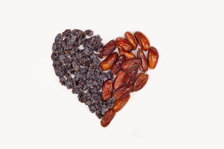 in the shape of a heart from raisins, dried grapes, dried dates. Concept of Valentine's day and healthy vegetarian food. Healthy food love concept. Natural products with glucose.の写真素材