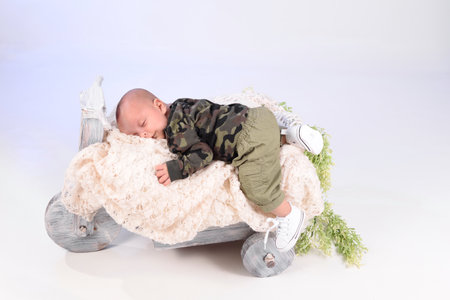 baby in trendy baby clothes sleeps cute with smile on soft knitted plaid,happy kid,child protection concept. Gift greeting card projectの写真素材