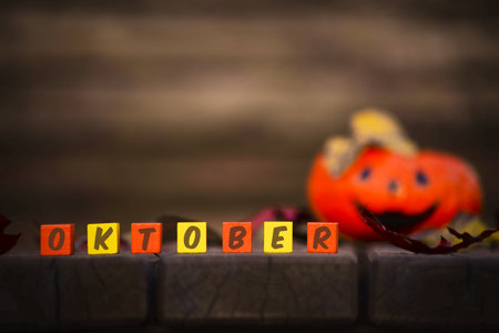 Words October on a Colored cubes with a laughing orange pumpkin out of focus. Halloween background.Autumn concept.の写真素材