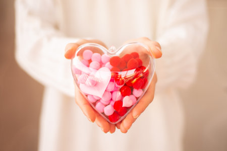 Background for Valentine's Day greeting card decorative souvenir transparent heart in human hands,...
