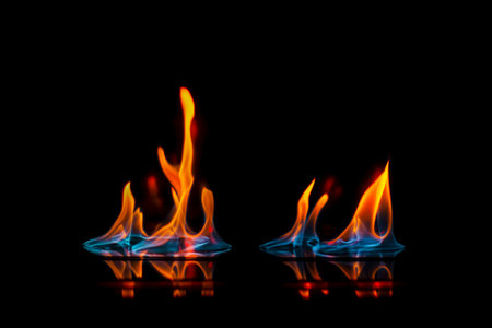 Intense flame, fire, burning brightly on a dark background, on a mirror surface with reflection,...