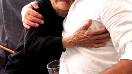 An elderly hundred-year-old man, grandmother, tightly hugs a middle-aged man with wrinkled arms. tenderness and trust between generationsの写真素材