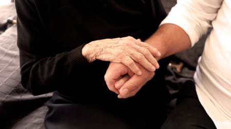 Hugs of a hundred-year-old woman and the young hands of an adult son, symbolizing support,...