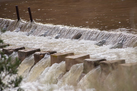A turbid, muddy rushing stream of overflowing river water. Floodの写真素材