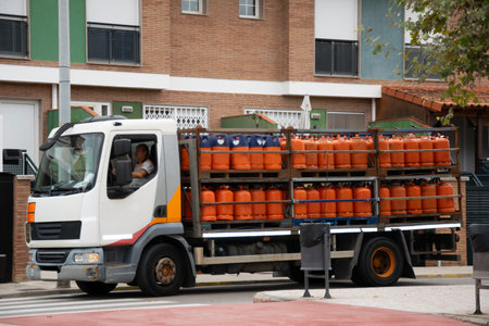 A truck with propane gas cylinders drives in a residential area of the city. Delivery of energy resources to the populationの写真素材
