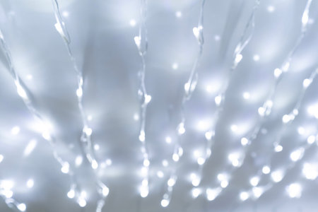 Festive background of blurred bokeh from Christmas illumination light garlandの写真素材