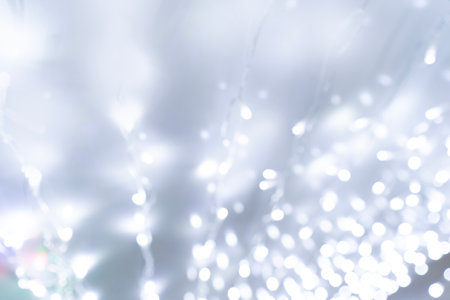 Festive background of blurred bokeh from Christmas illumination light garlandの写真素材