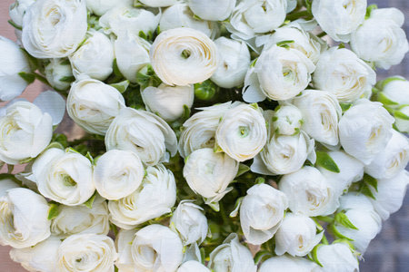 Bright floral bouquet with rustic style with white ranunculus buttercups and purple flowers, succulents and greenery on wooden background. Online flower gift shopの写真素材