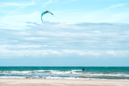 Kitesurfer in the ocean near the beach under blue wave backgroundの写真素材