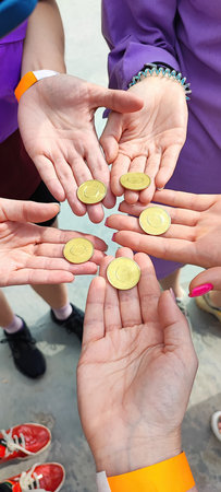 round metallic gold coins without inscriptions lie on open palms of handsの写真素材