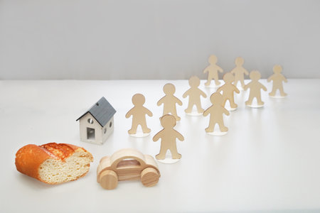 Figures of people stand in front of the house, a loaf of bread, a car