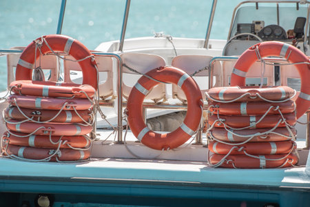 There are many lifebuoys on the deck of a ship, stacked on top of each other for emergencies....