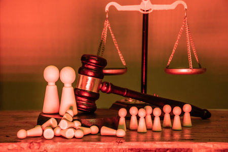 Gavel, scales of justice, and large and small wooden figurines. A judicial decision in favor of those in power or more powerful, authority, inequality of rights, social injustice, verdict, governanceの写真素材