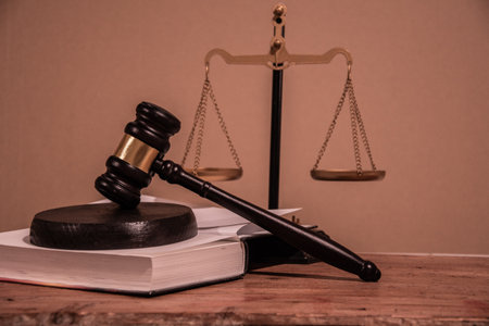 A courtroom table with a judge's gavel on a statute book and the scales of justice. The inviolability of the judicial system. Court decisions, the fairness of the courtの写真素材