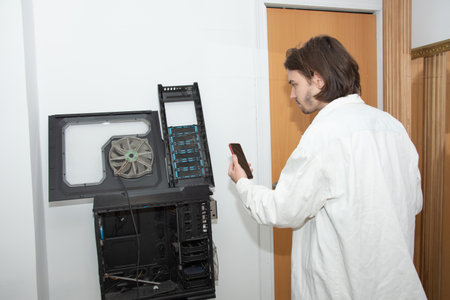 A technician repairs computer equipment using electronic components and tools. Electronics, hardware, workplaceの写真素材