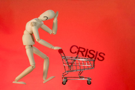 Concept of consumer crisis, inflation. a wooden mannequin sadly pushes an empty shopping cart with...