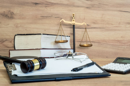 Judge gavel on legal documents with glasses, pen and scales of justice in background, law office and...