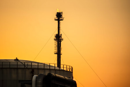 A refinery flare unit burning gas at sunset sunset. Oil refining, energy production, industrial...