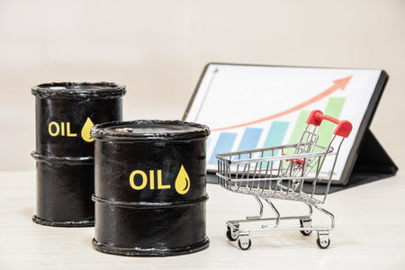Oil barrels with shopping cart and rising price chart on tablet representing fuel inflation and...