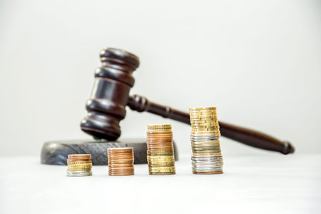 stacks of coins arranged in ascending order against a judge's gavel. Auction, legal business, taxes,...