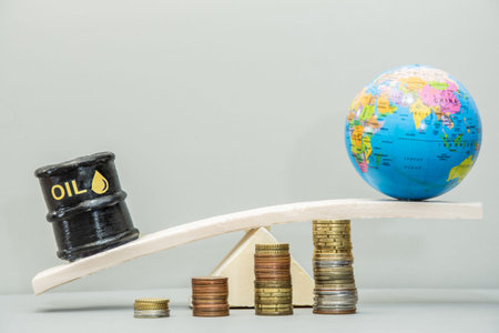 An oil barrel and globe balancing on a board above stacks of coins. Global economy, concept of price...