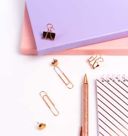 Notebooks and pen and stationery on a white background. Pastel color: pink and purple. Top view.の写真素材