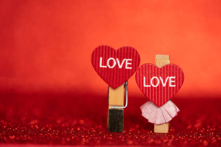 Clothespins with hearts on red background. Valentine day background with decorative hearts. Happy Valentine lovers day card mockup. Free space for your textの写真素材
