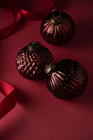 Three red vintage Christmas balloons ribbon on a red backgroundの写真素材