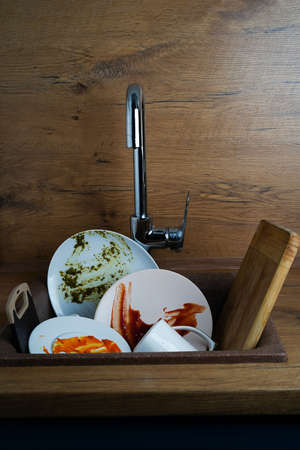 dirty dishes, dirty white plates in the kitchen sinkの写真素材
