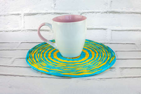 Colorful round handmade placemat of blue and yellow paper thread on white background.の写真素材