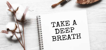 Conceptual inscription in a notebook on a wooden table. Design space in minimal style, postcard for your design or branding, simplicity and minimalism, nobody, flat lay, top view.の写真素材