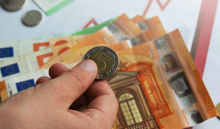 The house is on the table along with banknotes and manets. money savings planning in coins to buy a house, real estate concept, mortgage and real estate investment. To buy a house.の写真素材