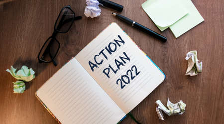 Notepad with an inscription on a financial or economic theme. Top view of a work desk along with business accessories. Conceptual image, business accessories, notebook, pen, crumpled paper, glasses.の写真素材