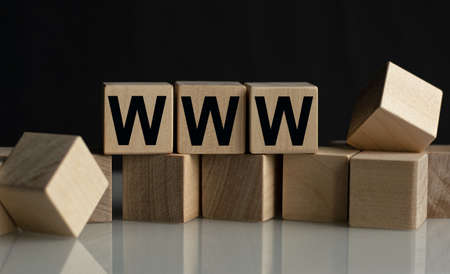The inscription WWW on wooden cubes isolated on a dark background, the concept of business and finance.の写真素材